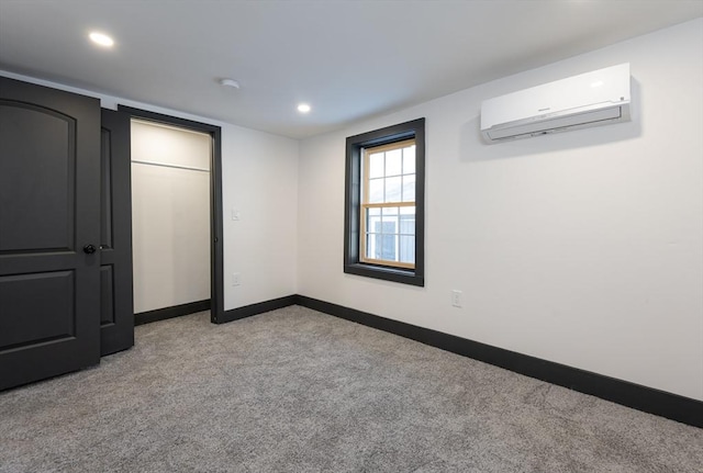 unfurnished bedroom with a wall mounted air conditioner and light colored carpet