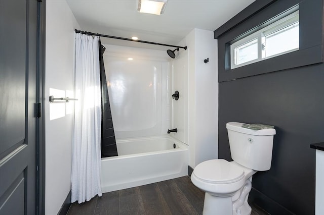 bathroom featuring wood-type flooring, shower / tub combo with curtain, and toilet