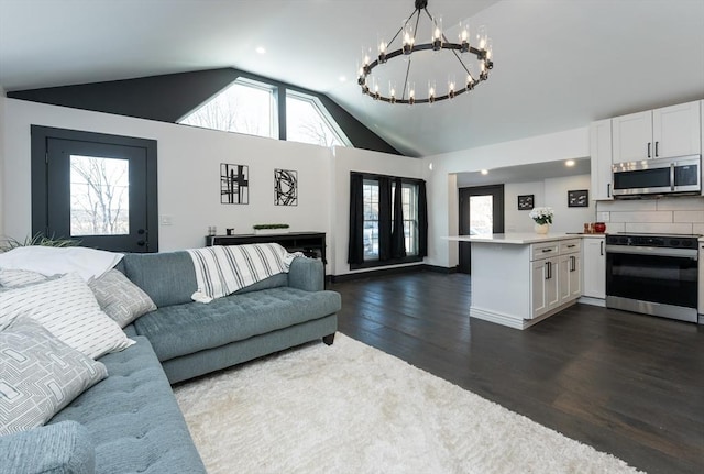 living room featuring high vaulted ceiling, dark wood-type flooring, and an inviting chandelier