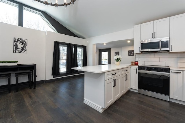 kitchen with range with electric stovetop, lofted ceiling, white cabinets, dark hardwood / wood-style flooring, and kitchen peninsula