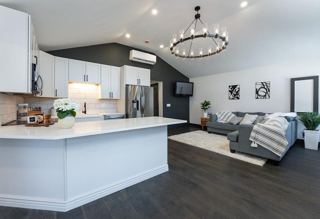 kitchen with lofted ceiling, a wall mounted air conditioner, dark hardwood / wood-style flooring, stainless steel appliances, and white cabinets