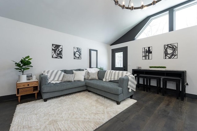 living room featuring dark wood-type flooring, a chandelier, and high vaulted ceiling