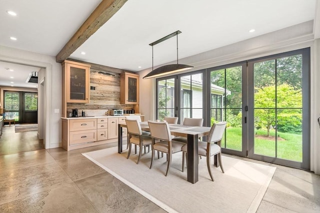 dining room featuring wooden walls, a wealth of natural light, beamed ceiling, and recessed lighting