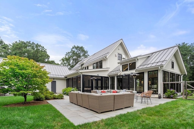 rear view of property with a patio, a sunroom, metal roof, an outdoor living space, and a standing seam roof