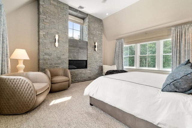 bedroom featuring carpet, visible vents, a fireplace, and high vaulted ceiling