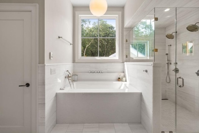 bathroom with a shower stall, a bath, tile walls, and plenty of natural light