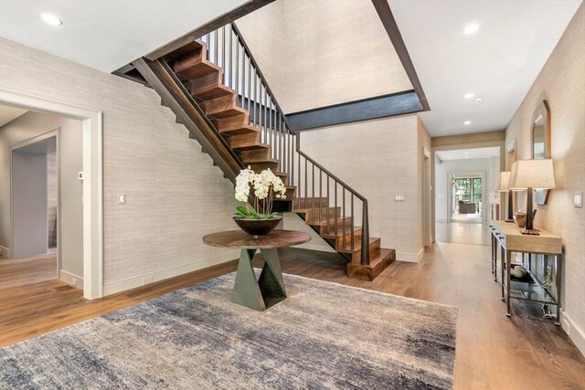 stairs with recessed lighting, baseboards, and wood finished floors