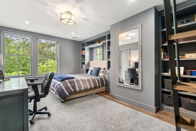 bedroom with wood finished floors, baseboards, and recessed lighting