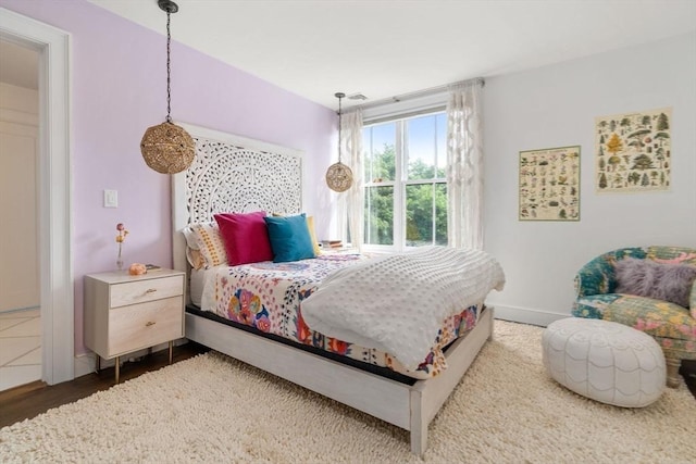 bedroom featuring baseboards and wood finished floors