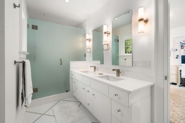 bathroom featuring double vanity, a shower stall, and a sink