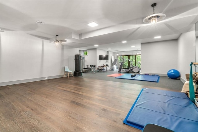 exercise area featuring baseboards, visible vents, and wood finished floors