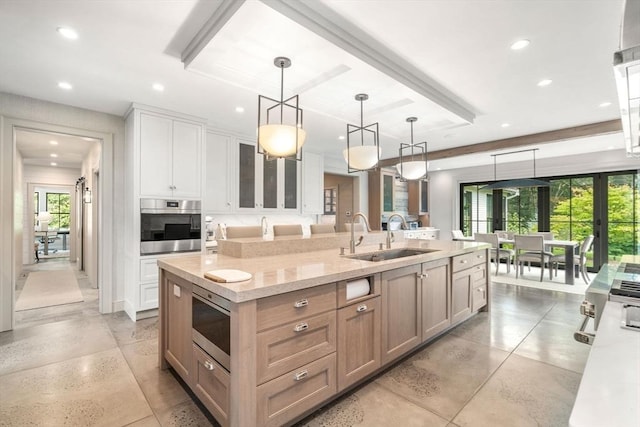 kitchen featuring a sink, stainless steel appliances, white cabinets, a spacious island, and recessed lighting