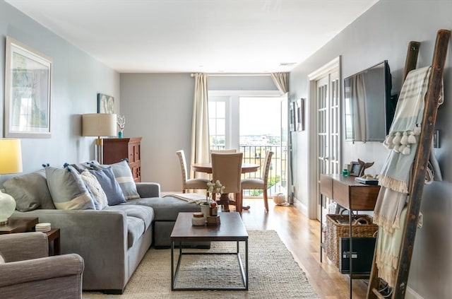 living area featuring light wood-style flooring and french doors