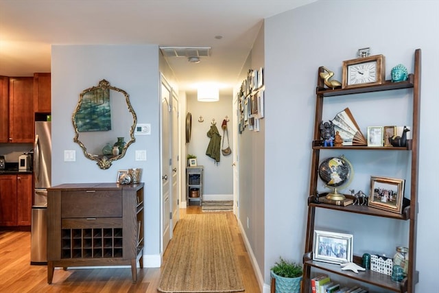 hallway with light wood-style floors and baseboards