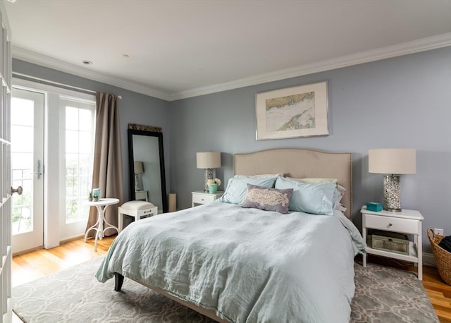 bedroom with ornamental molding and wood finished floors