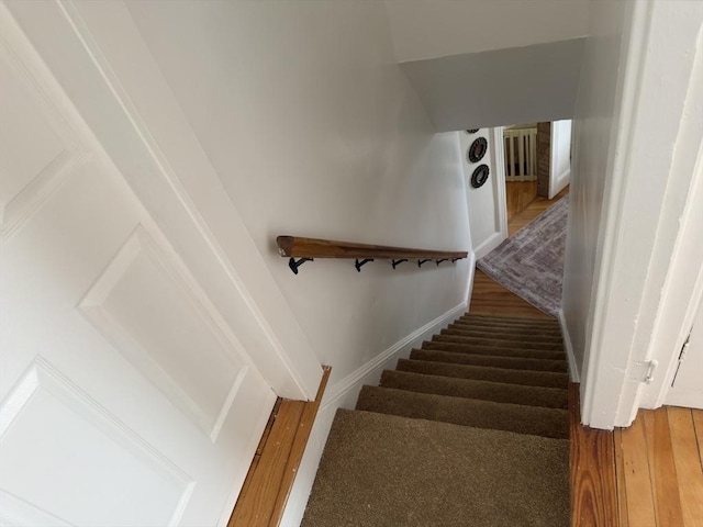 staircase with wood finished floors and baseboards