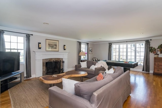 living area featuring a fireplace, crown molding, light wood finished floors, and pool table