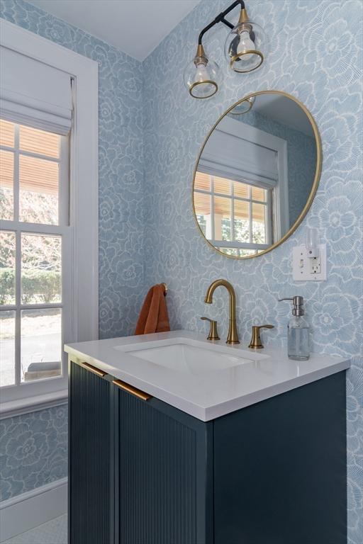 bathroom featuring wallpapered walls and vanity