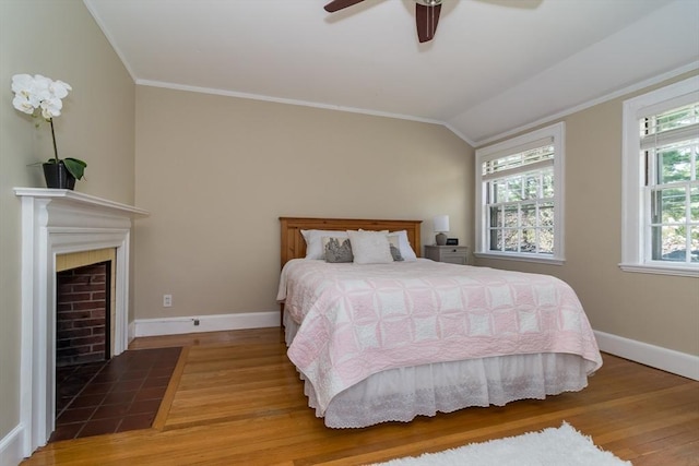 bedroom featuring wood finished floors, crown molding, and baseboards
