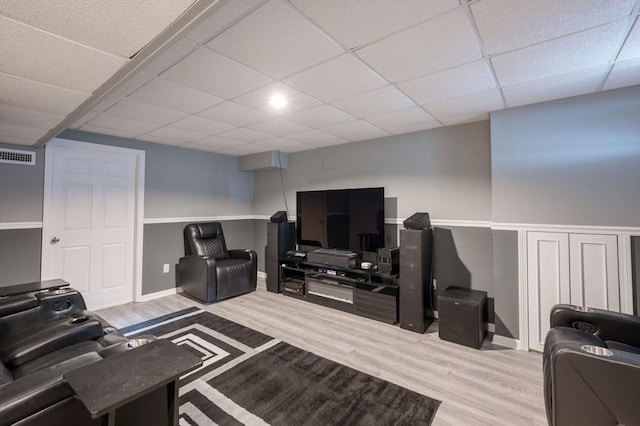 living room featuring a drop ceiling and light wood-type flooring