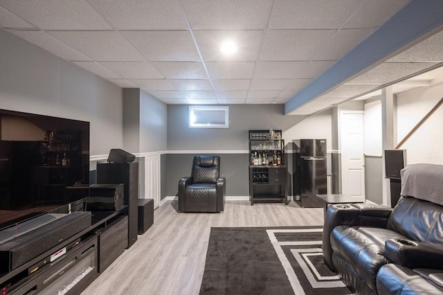 living room featuring a drop ceiling and light wood-type flooring