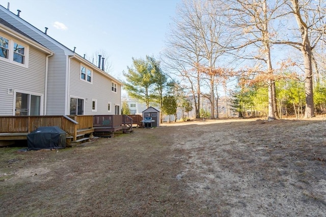 view of yard with a wooden deck and a shed