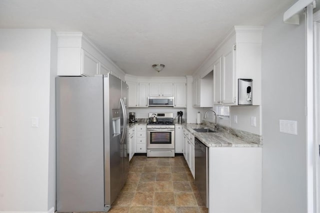 kitchen featuring stainless steel appliances, light stone countertops, sink, and white cabinets