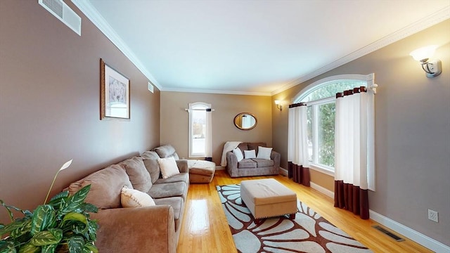 living area featuring light wood-style floors, crown molding, and baseboards