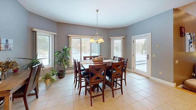 dining room with a chandelier, baseboards, and light tile patterned floors