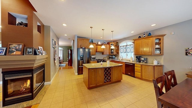 kitchen with black dishwasher, high end refrigerator, a sink, a multi sided fireplace, and light tile patterned flooring