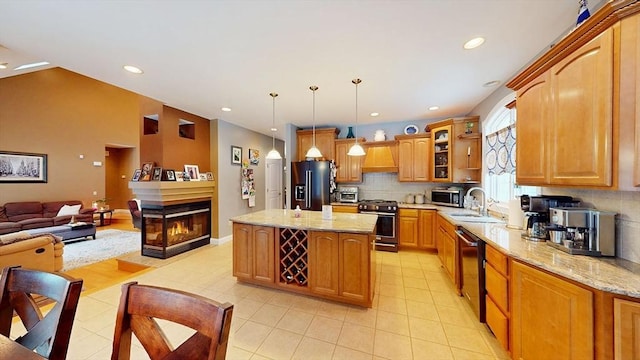 kitchen featuring black appliances, a sink, premium range hood, a kitchen island, and decorative backsplash