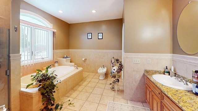 bathroom with vanity, a shower stall, a garden tub, wainscoting, and tile patterned floors