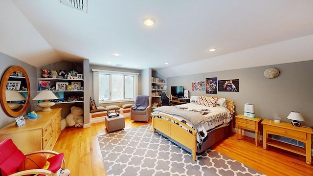 bedroom with vaulted ceiling and light wood-style flooring