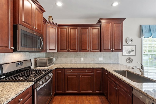 123 Skyline Dr Unit 123, Acton, MA 01720 - kitchen featuring appliances with stainless steel finishes, a sink, light stone countertops, dark wood-style floors, and recessed lighting