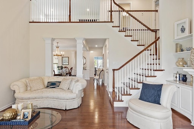 123 Skyline Dr Unit 123, Acton, MA 01720 - living room with a high ceiling, decorative columns, stairs, dark wood-style floors, and a chandelier