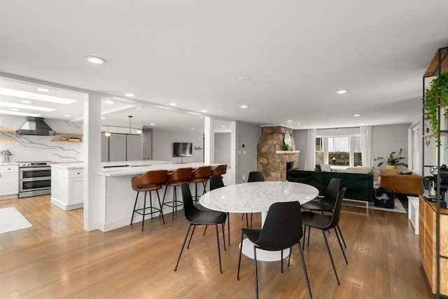 21 Glenley Ter, Boston, MA 02135 - dining space with light wood-style flooring, recessed lighting, and a stone fireplace