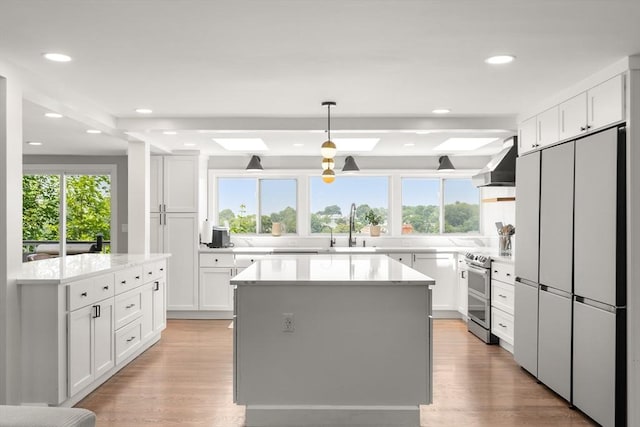 21 Glenley Ter, Boston, MA 02135 - kitchen with double oven range, white refrigerator, ventilation hood, a center island, and a skylight