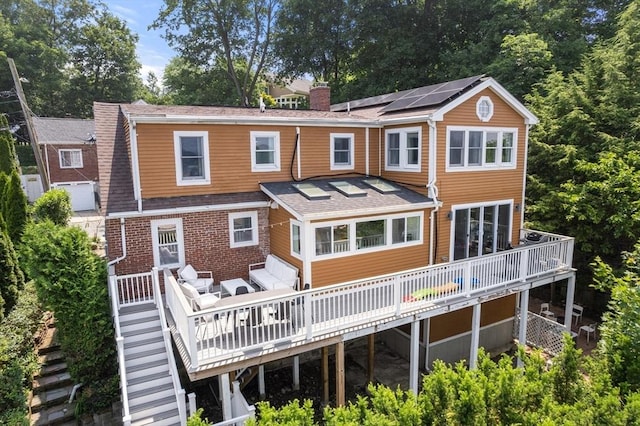21 Glenley Ter, Boston, MA 02135 - rear view of property with a chimney, solar panels, stairway, and a deck
