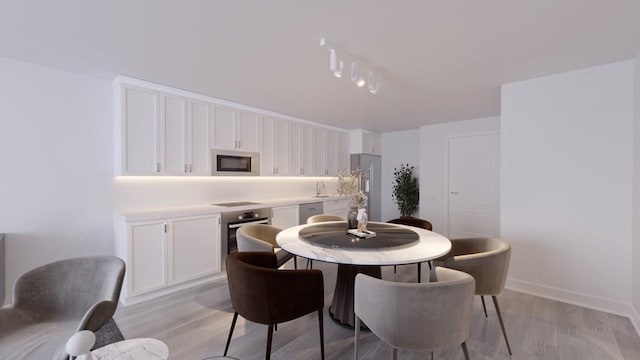 dining space with sink and light hardwood / wood-style flooring