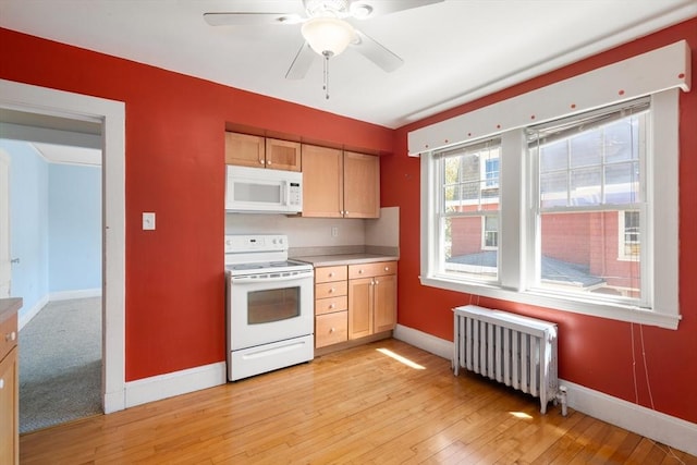 kitchen with a ceiling fan, baseboards, radiator, white appliances, and light wood-style flooring