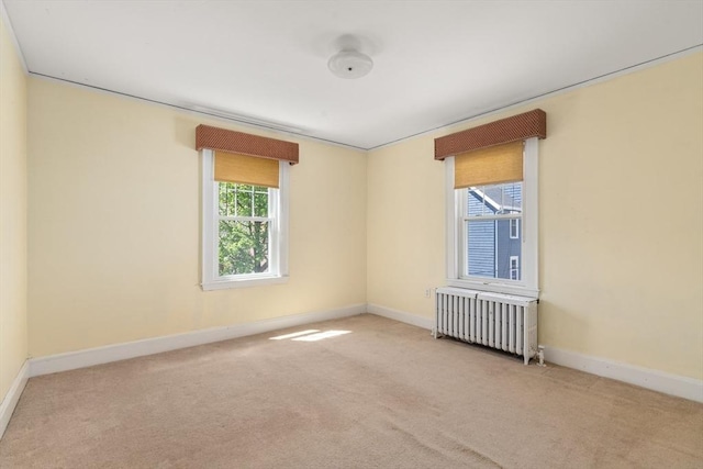 unfurnished room featuring carpet floors, baseboards, and radiator