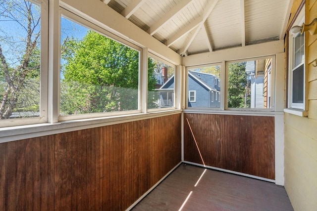 unfurnished sunroom with vaulted ceiling with beams and wood finished floors