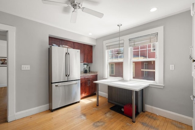 kitchen with ceiling fan, light countertops, light wood-style flooring, freestanding refrigerator, and baseboards