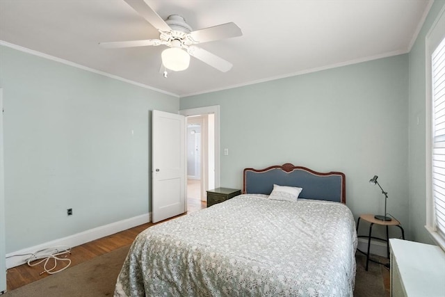 bedroom with crown molding, baseboards, multiple windows, and wood finished floors