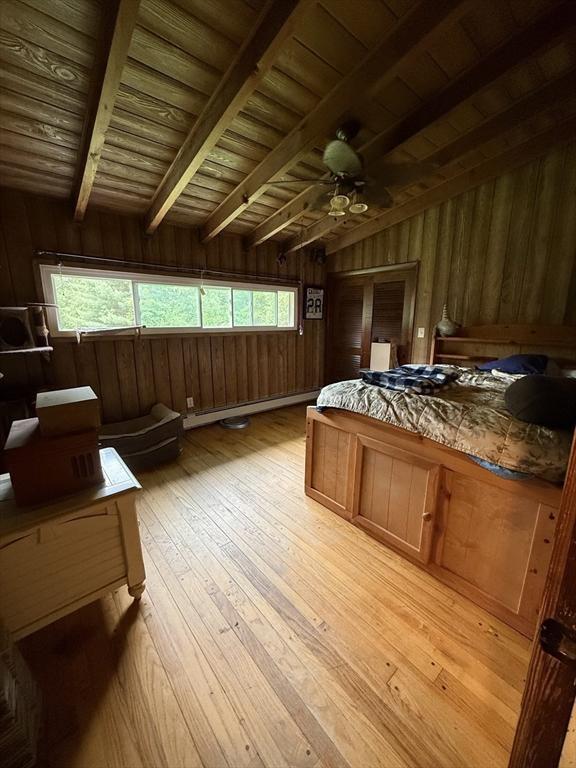166 Fairview Ave, Rehoboth, MA 02769 - bedroom featuring wood walls, wood ceiling, light wood-type flooring, multiple windows, and a baseboard radiator
