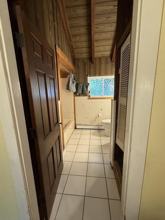 166 Fairview Ave, Rehoboth, MA 02769 - hall with wooden ceiling, lofted ceiling, wooden walls, and light tile patterned floors