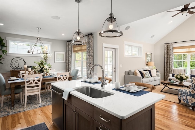 kitchen featuring dark brown cabinetry, sink, plenty of natural light, hanging light fixtures, and stainless steel dishwasher