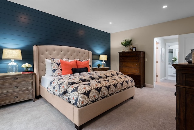 bedroom featuring light carpet and wooden walls