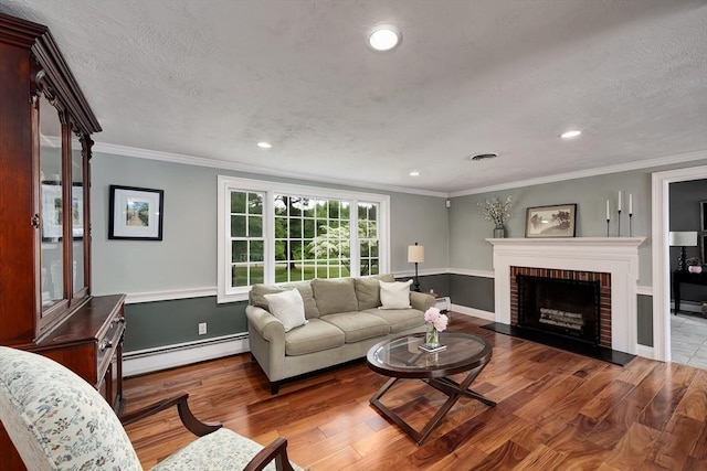 7 Perkins Row, Topsfield, MA 01983 - living area featuring baseboard heating, wood finished floors, a brick fireplace, recessed lighting, and crown molding