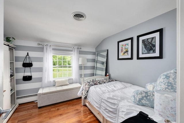 7 Perkins Row, Topsfield, MA 01983 - bedroom with a baseboard heating unit, lofted ceiling, wood finished floors, and a barn door